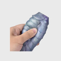 The Ice Dragon Cock Sleeve held in hand, displaying its flexibility and generous length enhancement.